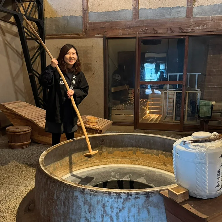 Momoko experiencing traditional sake brewing at a Japanese brewery